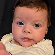 Alyah participe au concours pour gagner de l'argent avec cette photo : baby, infant, face, blue_eyes, curious, close_up, expression, child, portrait, cute, soft_light, brown_hair, skin, looking, hand, white_clothing, indoor, young, person, candid