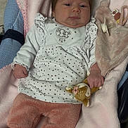 Yara participe au concours pour gagner de l'argent avec cette photo : baby, infant, blanket, plush_toy, pacifier, clothing, pink, white, star_pattern, soft_texture, cute, child, portrait, indoors, lying_down, young_child, face, hand, footwear, fabric