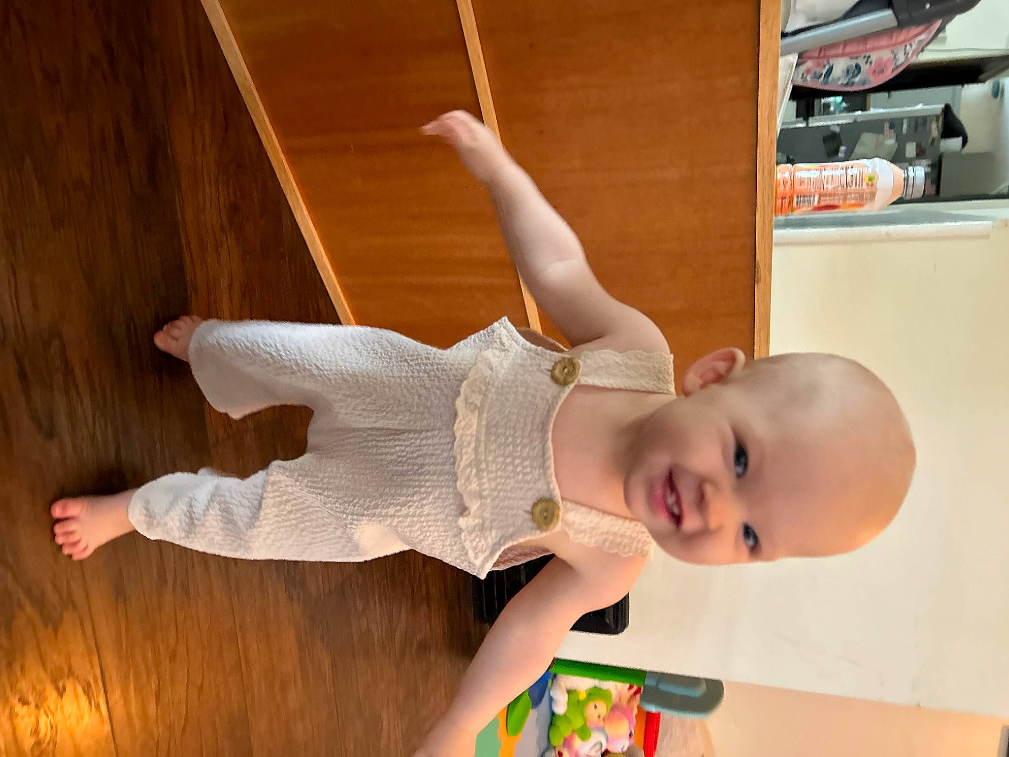 Rose is registered to the contest to win money with this photo: abdomen, baby, baby_toddler_clothing, child, elbow, flooring, happy, hardwood, human_body, human_leg, joy, knee, orange, person, shelf, smile, stairs, thigh, toddler, trunk