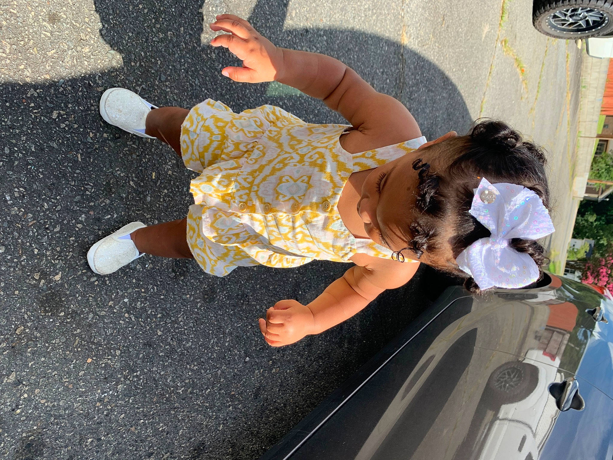 Ahnava Ivette is registered to the contest to win money with this photo: asphalt, automotive_exterior, car, dress, foot, fun, human_leg, leisure, mechanical_fan, pedestrian, person, plant, road, road_surface, sandal, sidewalk, thigh, toddler, vehicle_door