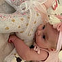 baby, infant, teddy_bear, stuffed_animal, pink_dress, headband, flower, cute, child, hugging, soft_toy, blanket, fabric, patterned, floral, closeup, indoors, portrait, adorable, sleepy