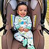 baby, baby_clothing, baby_garment, car_seat, caterpillar_design, child, cute, fabric, footies, happy, head_support, infant, infant_footwear, onesie, outdoor, person, seatbelt, sitting, smiling, sunlight