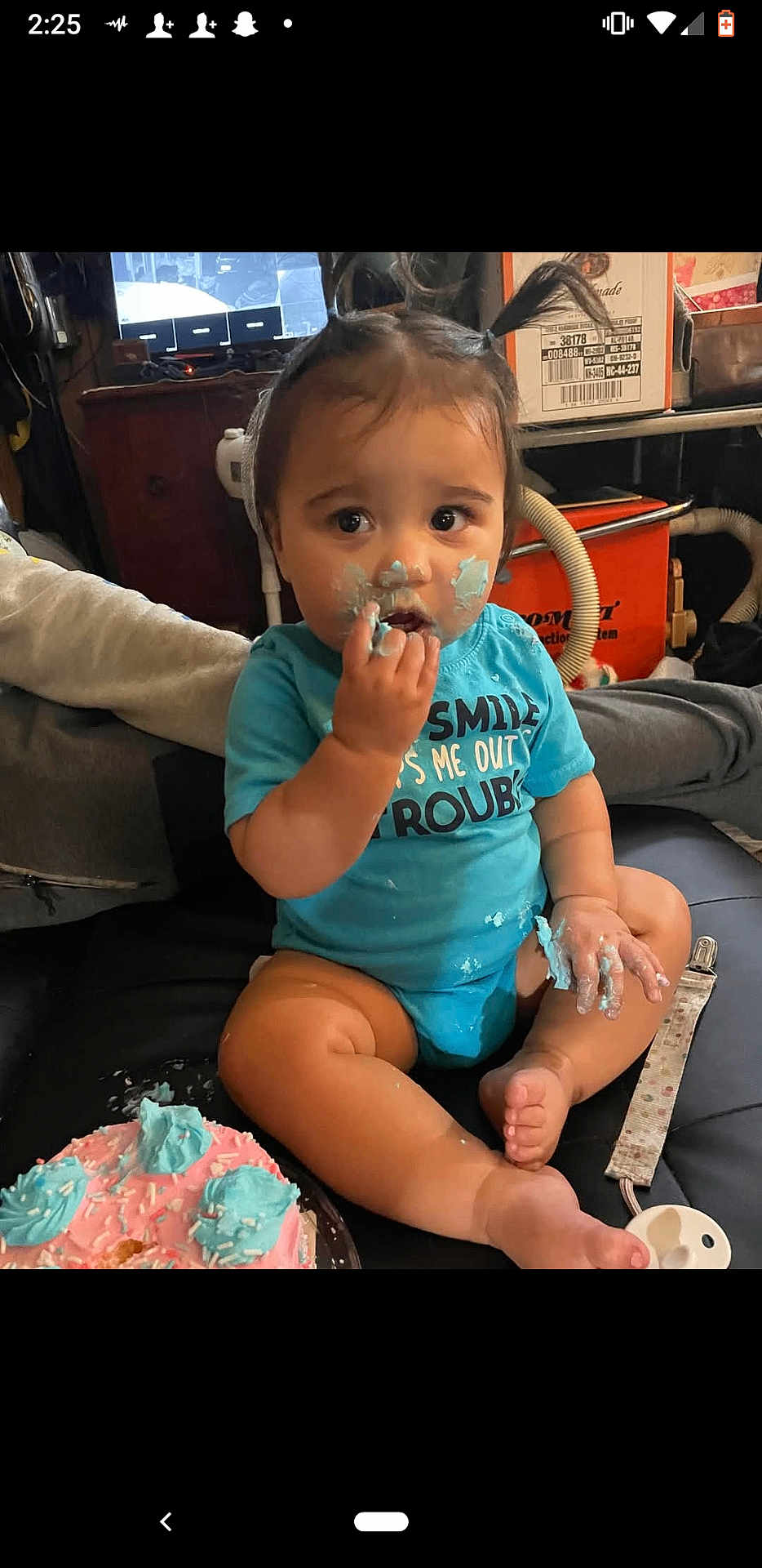 Oktavia is registered to the contest to win money with this photo: baby, child, cake, frosting, blue_frosting, pink_cake, sitting, indoors, curious, messy, pigtails, cute, small_hands, foot, face, food, eating, toddler, person, casual