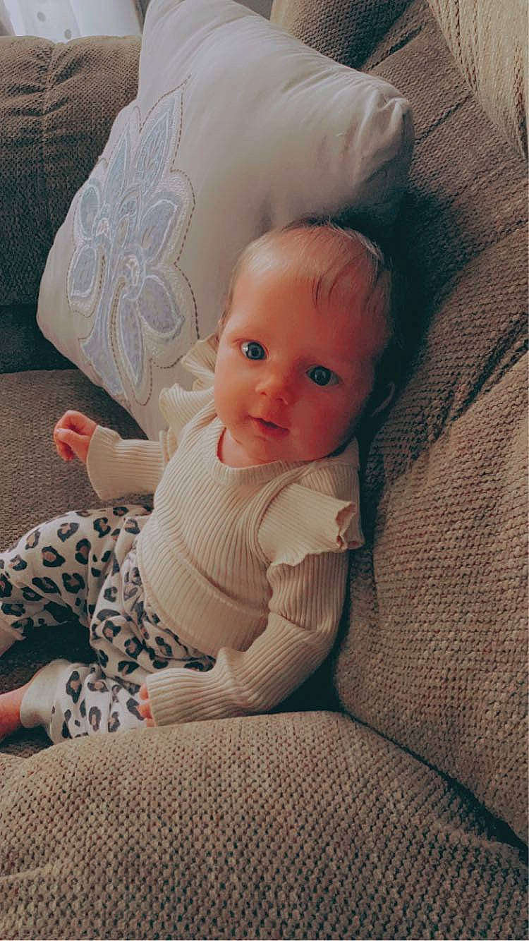 Hadley is registered to the contest to win money with this photo: baby, baby_toddler_clothing, cheek, child, comfort, doll, eye, eyelash, flooring, head, iris, linens, lip, nose, person, sitting, skin, textile, toddler, toy