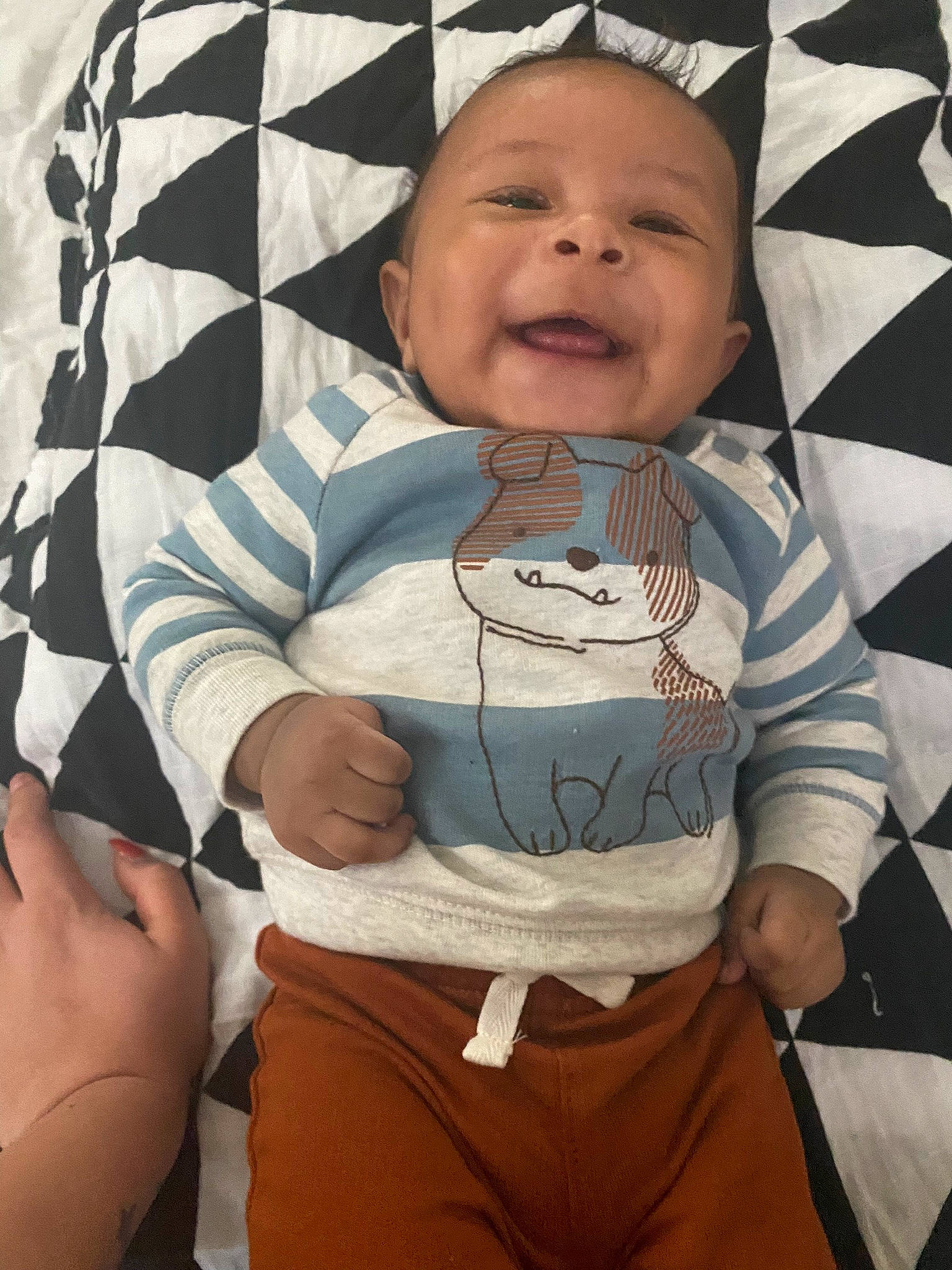 Lorenzo is registered to the contest to win money with this photo: arm, baby, baby_toddler_clothing, black, child, clothing, comfort, facial_expression, finger, gesture, hand, happy, outerwear, people, person, sleeve, smile, t_shirt, textile, toddler