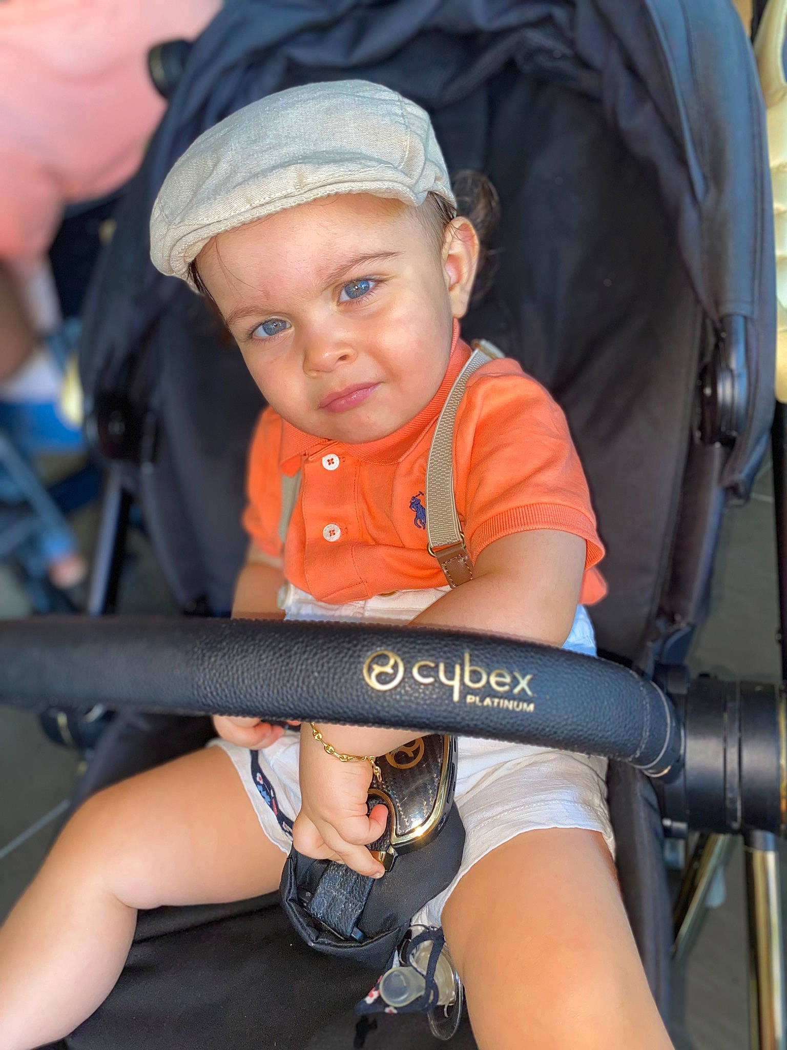Darell participe au concours pour gagner de l'argent avec cette photo : baby_carriage, baseball_cap, chair, child, comfort, elbow, electric_blue, finger, fun, hand, headwear, human_leg, knee, lap, leisure, person, product, shorts, sitting, thigh