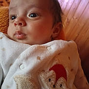 Louis a rejoint le concours — aidez-le/la à gagner de superbes lots ! baby, blanket, calm, cheek, closeup, clothing, cozy, embroidery, eyes, face, gaze, indoor, infant, lips, newborn, onesie, portrait, soft_lighting, soft_texture, wood_paneling