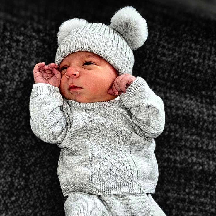 Jett is registered to the contest to win money with this photo: baby, beanie, bonnet, cap, clothing, face, glove, hat, head, hood, knitwear, newborn, person, photography, portrait, sleeping, sweater, yawning
