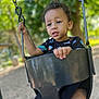 Nazir joined the competition — help win amazing prizes! child, toddler, swing, playground, outdoor, trees, greenery, daylight, chain, black_swing_seat, curly_hair, short_sleeve_shirt, colorful_clothing, person, grip, expression, park, blurred_background, recreation, fun