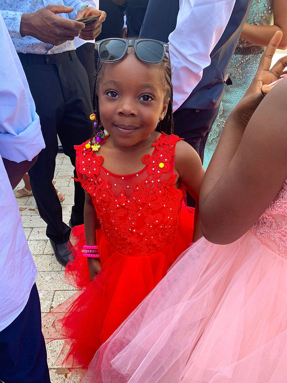 Djeneba a rejoint le concours — aidez-le/la à gagner de superbes lots ! child, dress, event, facial_expression, fashion, fun, gesture, goggles, hairstyle, happy, hat, human, interaction, joy, magenta, person, pink, red, smile, sunglasses