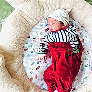 Sambhrit joined the competition — help win amazing prizes! newborn, baby, sleeping, plush_toy, teddy_bear, bed, red_overalls, striped_shirt, hat, cushion, leaf_pattern, green_blanket, infant, cozy, soft, cute, child, resting, indoors, comfort