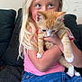 child, girl, kitten, cat, blonde_hair, pink_shirt, denim_skirt, couch, indoor, pet, holding, cute, young, happy, feline, animal, portrait, cozy, casual, love