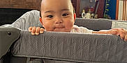 Anthony joined the competition — help win amazing prizes! baby, child, playpen, red_pants, indoor, living_room, plant, cabinet, window, sunlight, toys, curious, hands, face, smiling, home, furniture, photography, person, cozy