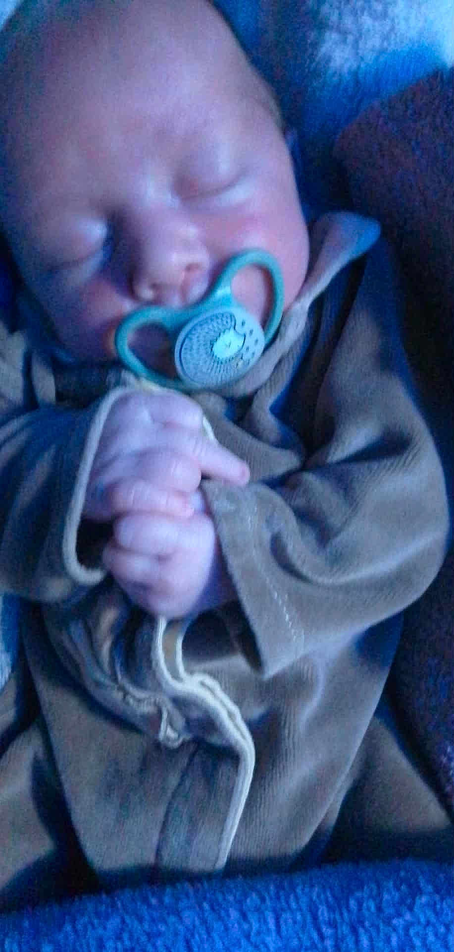 Maël participe au concours pour gagner de l'argent avec cette photo : baby, sleeping, pacifier, hand, clothing, blanket, blue_light, infant, cute, peaceful, soft_texture, closeup, face, newborn, portrait, cozy, wrapped, child, tiny_hands, resting