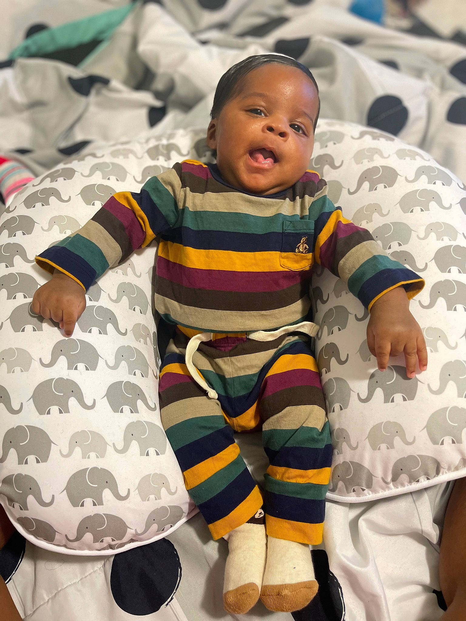 Ashton is registered to the contest to win money with this photo: baby, baby_products, baby_toddler_clothing, child, comfort, fun, happy, linens, pattern, person, personal_protective_equipment, play, product, sitting, sleeve, smile, t_shirt, textile, toddler, uniform