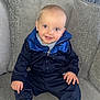 Freddie is registered to the contest to win money with this photo: baby, blue, casual, child, clothing, comfort, couch, face, footwear, happy, head, indoor, navy, person, portrait, sitting, smiling, sneakers, tracksuit, young_child
