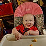 baby, high_chair, smiling, snack, food, indoor, child, pink, red_shirt, face, happy, furniture, table, tray, clutter, storage, expression, cute, person, young