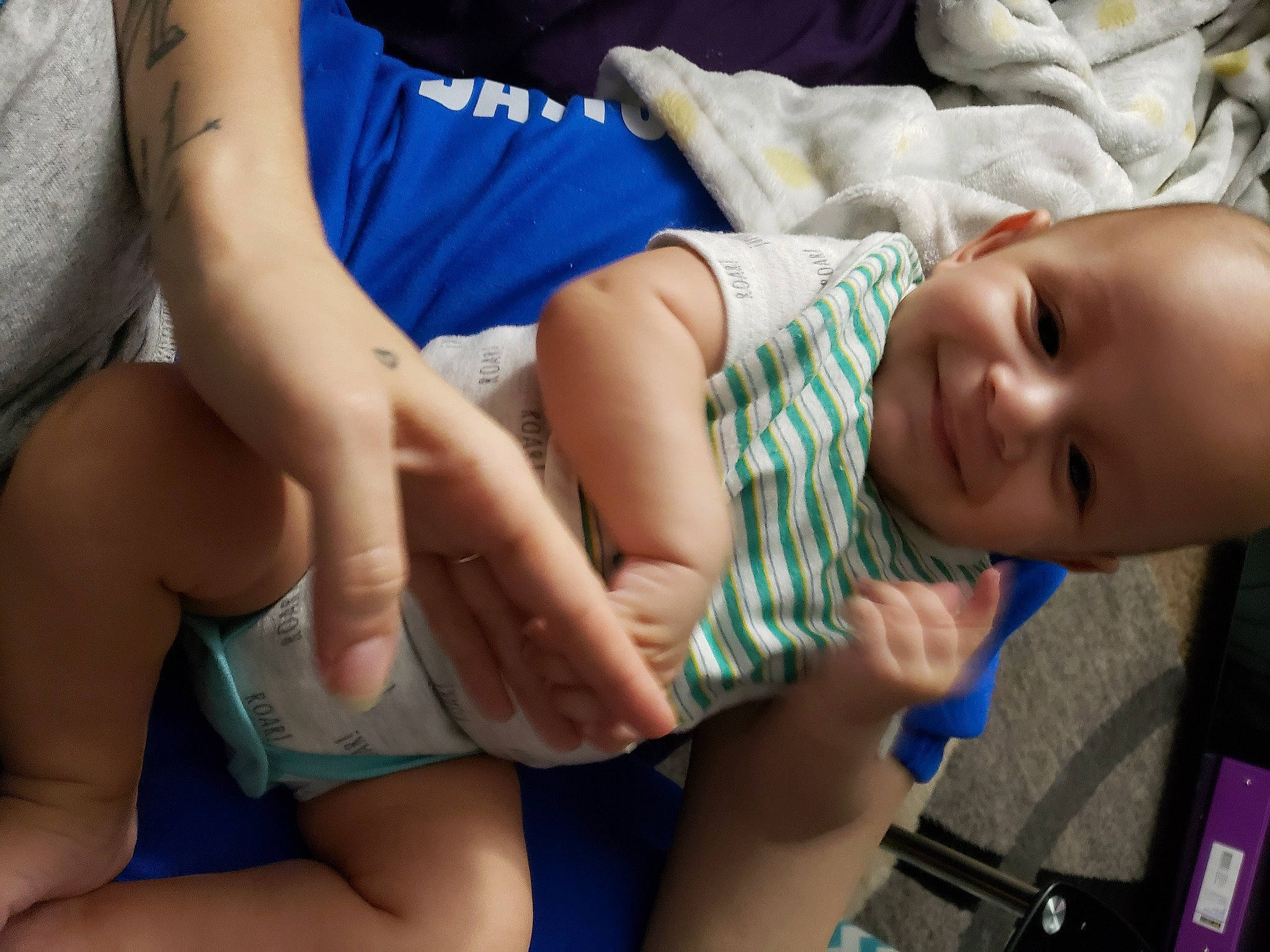 Maverick is registered to the contest to win money with this photo: baby, blue, cheek, chest, comfort, elbow, finger, gesture, hand, human_body, joint, joy, leg, mammal, mouth, muscle, person, skin, smile, thigh