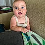 baby, child, infant, blue_eyes, blanket, couch, indoor, person, portrait, cute, curious, chubby_cheeks, knit_clothing, texture, comfort, home, seated, hand, expression, furniture
