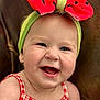 Helena is registered to the contest to win money with this photo: baby, infant, smiling, headband, bow, red, green, checkered_dress, cute, happy, portrait, face, child, cheerful, closeup, skin, earring, sitting, indoor, background