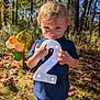 Jaxson joined the competition — help win amazing prizes! child, toddler, boy, number_two, birthday, outdoor, balloons, autumn, leaves, grass, smile, curly_hair, blue_shirt, jeans, daylight, nature, trees, celebration, toy_elephant, happy