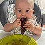 baby, child, eating, food, meat, high_chair, bib, plate, messy, indoor, person, table, curious, face, hands, cute, infant, closeup, mess, background_person