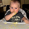 baby, child, cute, eating, face, feeding, food, hands, highchair, indoor, infant, kitchen, mess, messy, person, shirt, smearing, table, wide_eyes, yellow_food