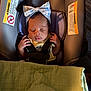 baby, infant, sleeping, car_seat, headband, bow, blanket, safety_strap, peaceful, indoors, child, cute, serene, portrait, young_child, face, hands, clothing, soft_light, resting