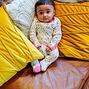 Heer is registered to the contest to win money with this photo: baby, baby_toddler_clothing, bed_sheet, bedding, child, comfort, flooring, fun, grass, happy, leisure, linens, magenta, mammal, outerwear, sitting, textile, throw_pillow, toddler, wood