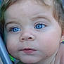 Shawn is registered to the contest to win money with this photo: baby, close_up, face, blue_eyes, curious, child, skin, hair, portrait, expression, young, infant, person, outdoor, metal_bar, background, colorful, soft_focus, head, cheek