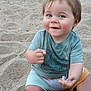 baby, beach, blue_eyes, cheeks, child, cute, fun, green_shirt, hands, happy, outdoor, playful, portrait, sand, shorts, sitting, smile, summer, sunlight, young_child