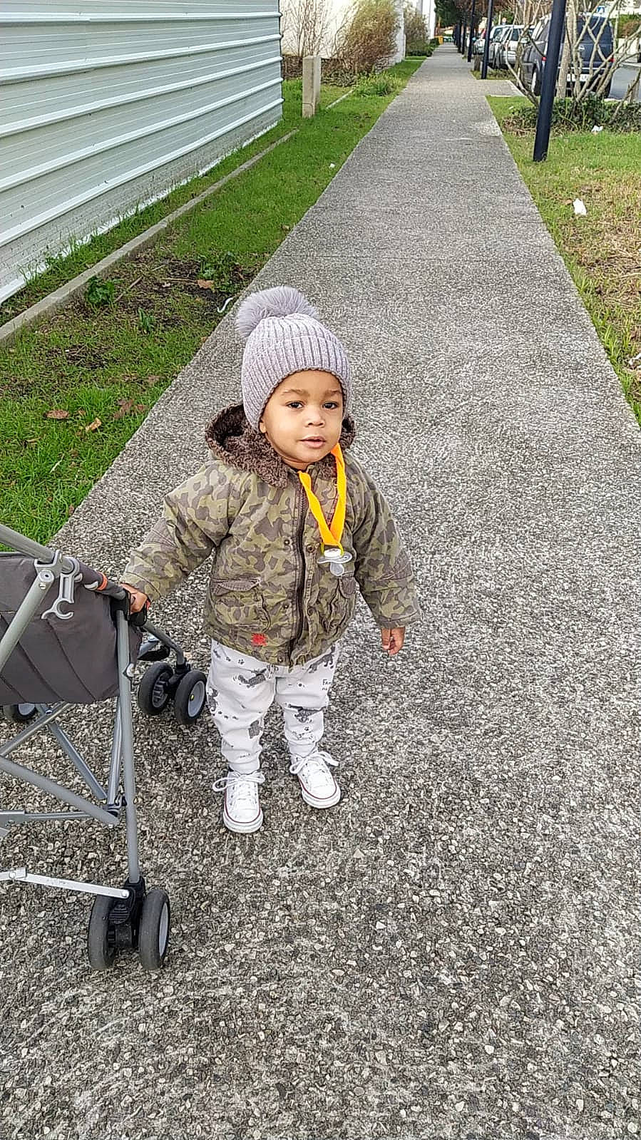 Jémaël participe au concours pour gagner de l'argent avec cette photo : asphalt, baby, child, city, fun, grass, headwear, infrastructure, leisure, people_in_nature, person, plant, recreation, road, road_surface, sidewalk, sitting, soil, tire, toddler