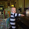 Ledger joined the competition — help win amazing prizes! baby, child, toddler, standing, smiling, striped_clothing, pajamas, table, home, indoor, living_room, toys, play_mat, ball_pit, aquarium, fish_tank, furniture, portrait, family_home, happy