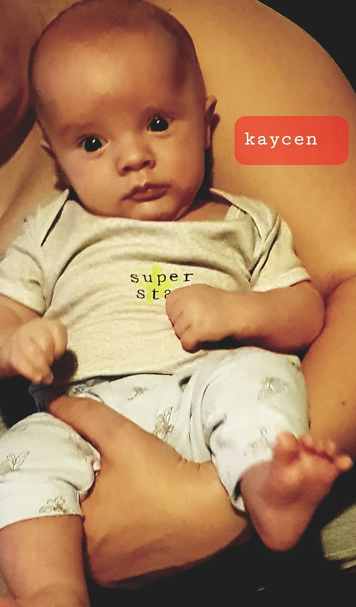 Kaycen is registered to the contest to win money with this photo: arm, baby, cheek, child, diaper, finger, leg, person, sitting, skin, thigh, toddler