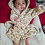 Baeleigh joined the competition — help win amazing prizes! baby, infant, child, giraffe_robe, hooded_robe, blanket, pillow, bed, smile, face, eyes, hand, foot, cozy, cute, soft_fabric, pattern, fabric, indoors, portrait
