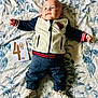 baby, infant, child, clothing, jacket, pants, shoes, blanket, pattern, floral, milestone_card, sloth, lying_down, cute, indoors, portrait, young_child, soft_lighting, fabric, baby_milestone