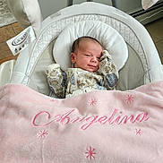 Angelina joined the competition — help win amazing prizes! newborn, baby, infant, baby_swing, blanket, pink_blanket, floral_onesie, sleeping, cozy, indoor, baby_bedding, child, cute, resting, soft_texture, home, comfort, baby_accessory, portrait, peaceful