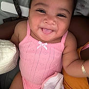 Athena is registered to the contest to win money with this photo: baby, child, smiling, tongue_out, pink_clothing, blanket, arm, skin, face, happy, cute, infant, indoors, person, closeup, sleeveless, fabric, soft, playful, joy