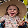 toddler, child, shopping_cart, hat, straw_hat, smiling, happy, indoor, store, aisle, clothing, patterned_shirt, purple_pants, person, cute, playful, retail, colorful, baby, fun