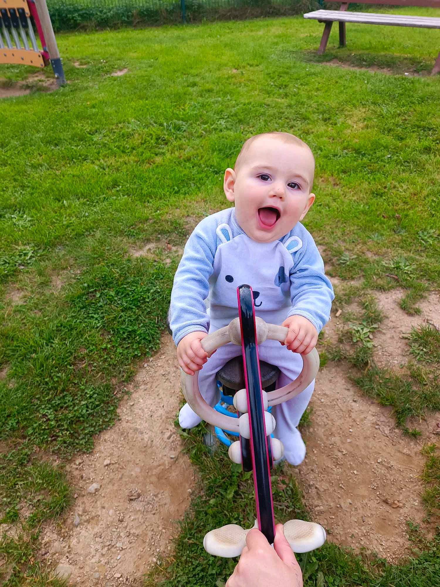 Abel participe au concours pour gagner de l'argent avec cette photo : baby, baby_products, baby_toddler_clothing, child, fun, garden, grass, leisure, outdoor_play_equipment, people_in_nature, person, play, recreation, riding_toy, sitting, smile, soil, surprise, tire, toddler