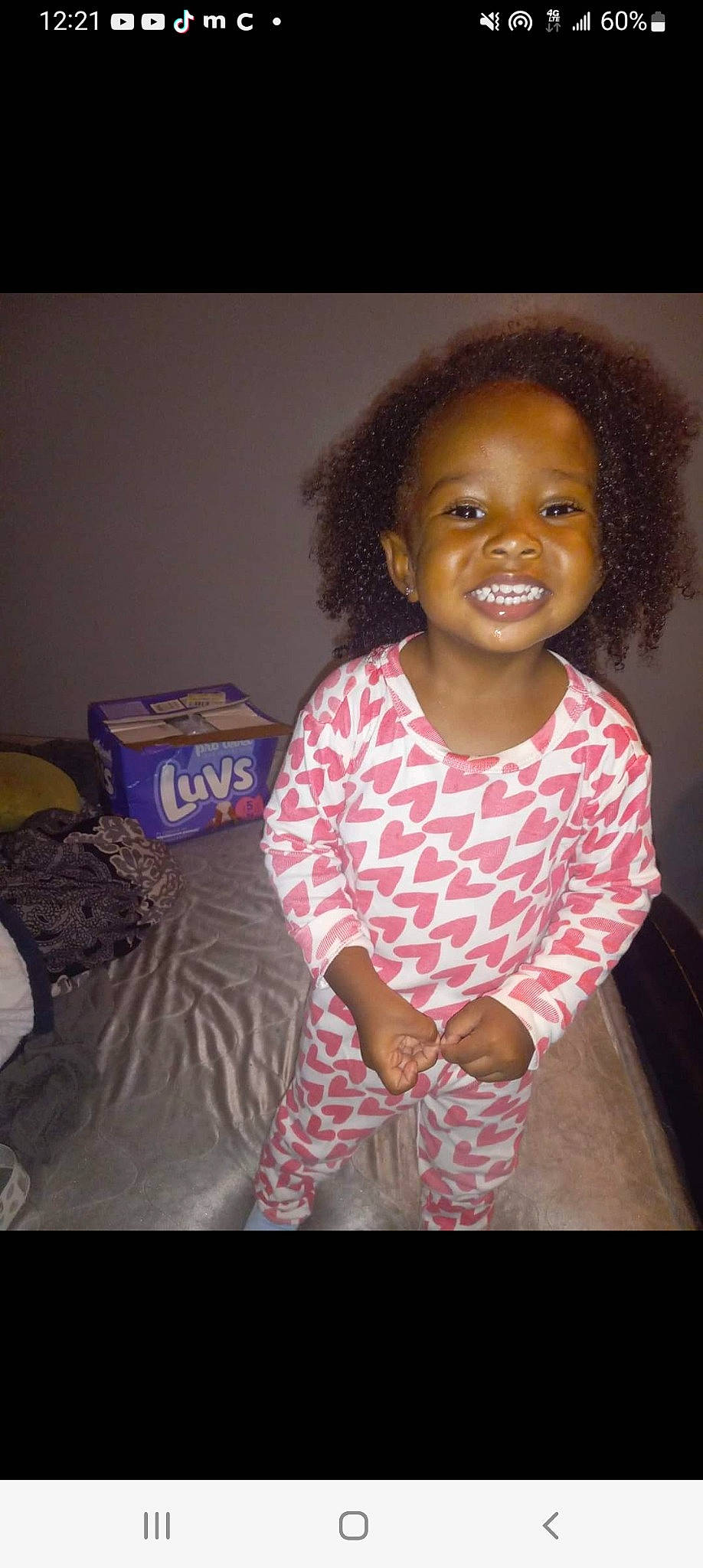 Kyra is registered to the contest to win money with this photo: afro, baby_toddler_clothing, cheek, child, fun, happy, iris, joy, laugh, linens, luggage_and_bags, magenta, pattern, person, pillow, sitting, skin, sleeve, smile, t_shirt