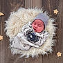 newborn, baby, sleeping, hat, pajamas, mittens, fluffy_rug, wooden_floor, felt_stars, felt_moon, cozy, cute, indoors, resting, peaceful, infant, portrait, soft_texture, decor, child