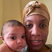 Ariella joined the competition — help win amazing prizes! baby, adult, headwrap, closeup, portrait, face, skin, expression, looking, eyes, person, indoor, curious, smile, family, bond, human, child, young, love