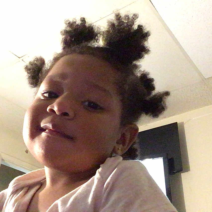 Ja'Mir is registered to the contest to win money with this photo: child, girl, indoor, portrait, hair_buns, face, smile, young, person, ceiling, room, door, television, casual_clothing, happy, cute, headshot, home, light, skin