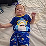 baby, child, infant, portrait, lying_down, bed, bedroom, quilt, blue_clothing, shark_shirt, pajamas, smiling, face, arms, legs, red_hair, indoor, casual, playful, photography
