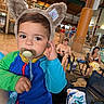 Kaiser is registered to the contest to win money with this photo: toddler, child, pacifier, hat, bear_ears, blue_swimsuit, indoor_pool, pool_area, adult, swimwear, chair, relaxing, phone, towel, table, wooden_structure, net, casual, family, leisure