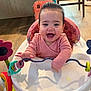 baby, walker, toy, smiling, indoor, child, pink_sweater, happy, floor, wooden_floor, furniture, chair, playtime, infant, colorful, hands, face, head, home, cute