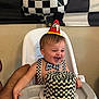 Ricky joined the competition — help win amazing prizes! toddler, birthday, high_chair, party_hat, cake, frosting, smiling, face, black_and_white, checkered_pattern, bow_tie, celebration, balloon, banner, indoor, child, happy, messy, person, food
