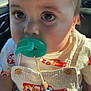 Ricky is registered to the contest to win money with this photo: baby, child, pacifier, overalls, clothing, face, eyes, infant, cute, indoors, car, seat, sunlight, closeup, person, young_child, accessory, beads, toy, expression