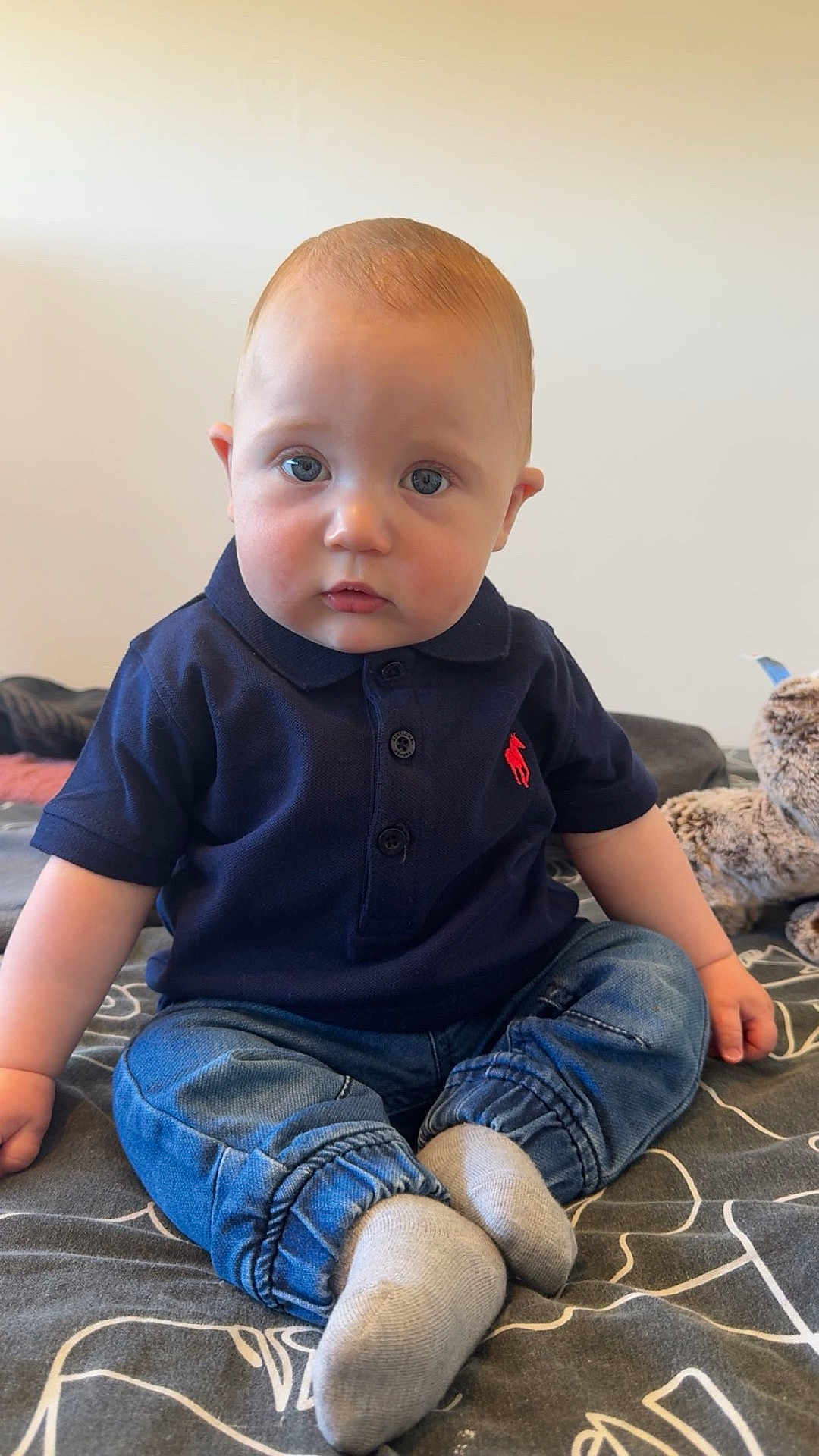 Meyven a rejoint le concours — aidez-le/la à gagner de superbes lots ! baby, blanket, blue_eyes, casual_clothing, child, curious_expression, cute, denim_pants, face, feet, hands, head, indoor, infant, navy_polo, plush_toy, portrait, sitting, socks, young_child